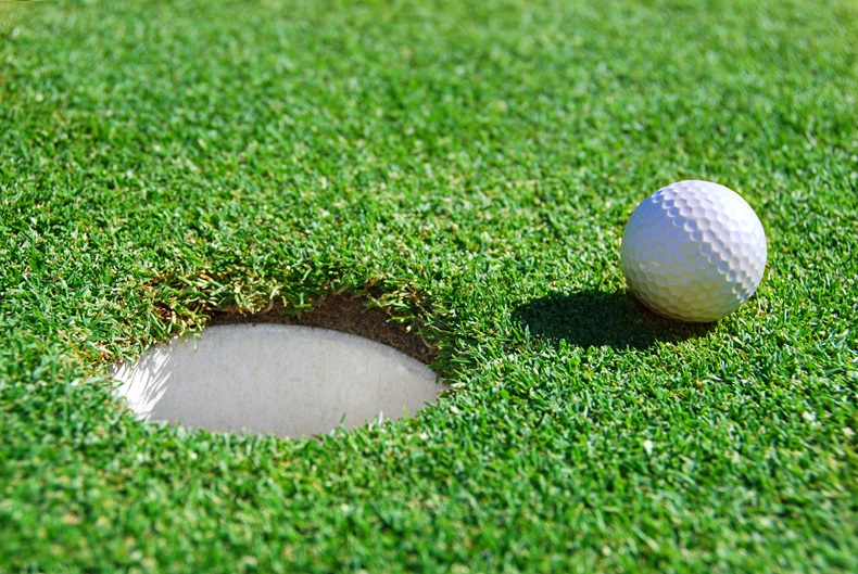 close up of Golf Ball Next to Cup 