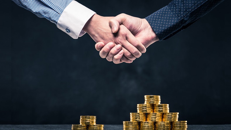 Handshake of businessman over coins