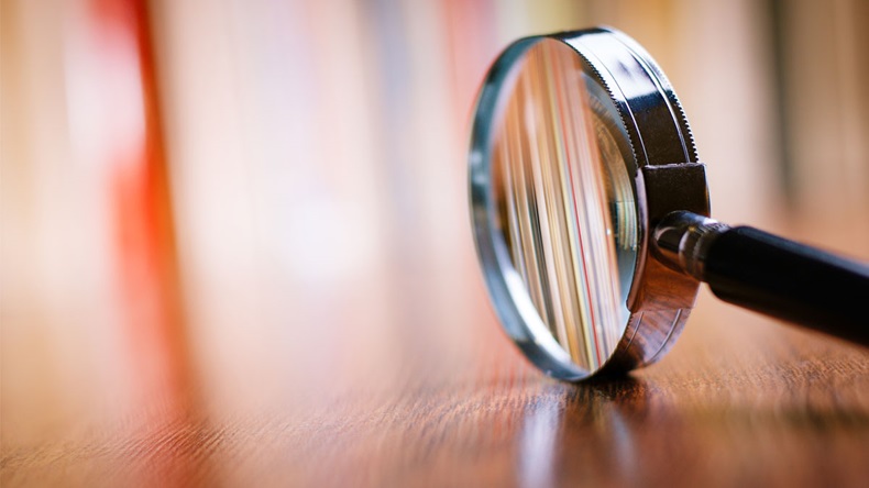 Close up Single Magnifying Glass with Black Handle, Leaning on the Wooden Table at the Office. - Image 