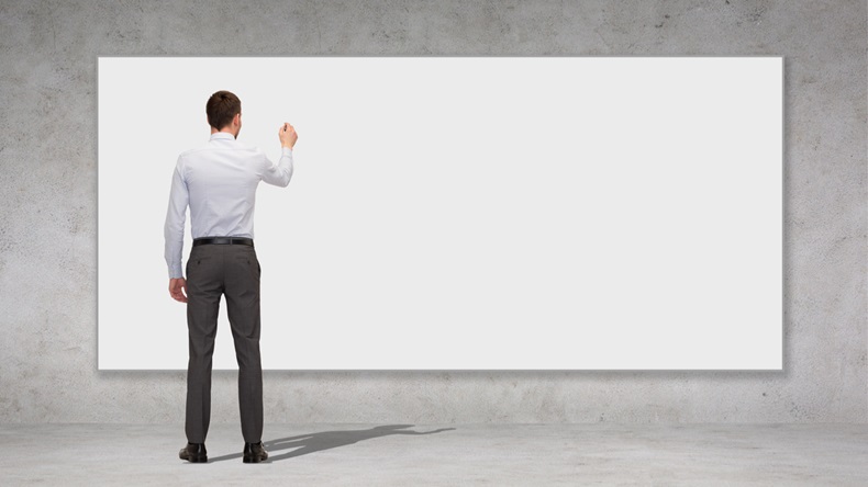business, education and office people concept - businessman or teacher with marker writing or drawing something on white blank board over concrete wall background from back - Image 