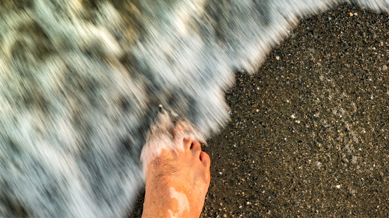 Man's legs with vitiligo on the sand beach - Image 