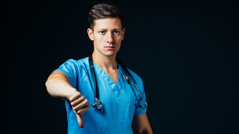 male doctor in studio, thumbs down, showing failed, bad news - Image 