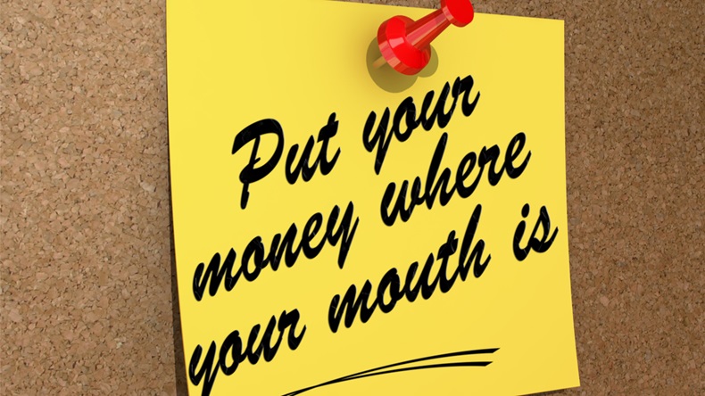 A note pinned to a cork board with the text Put Your Money Where Your Mouth Is.