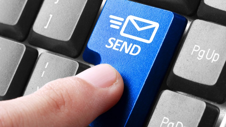 Sending email. gesture of finger pressing send button on a computer keyboard