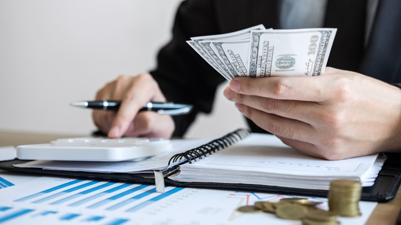 Businessman accountant counting money and making notes at report doing finances and calculate about cost of investment and analyzing financial data, Financing Accounting Banking Concept.