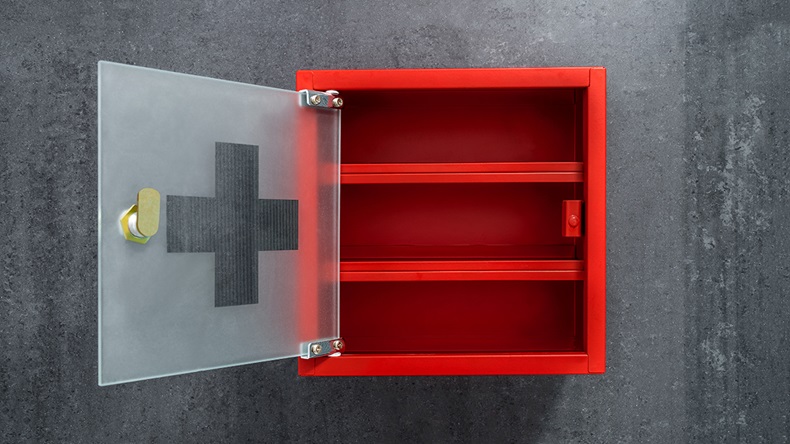 Open red metal empty medicine cabinet hanging on a dark gray marble wall background