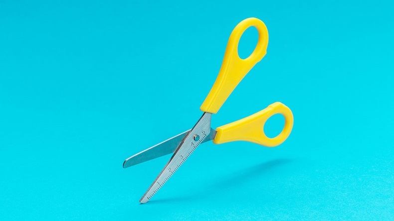 opened yellow scissors over turquoise blue background