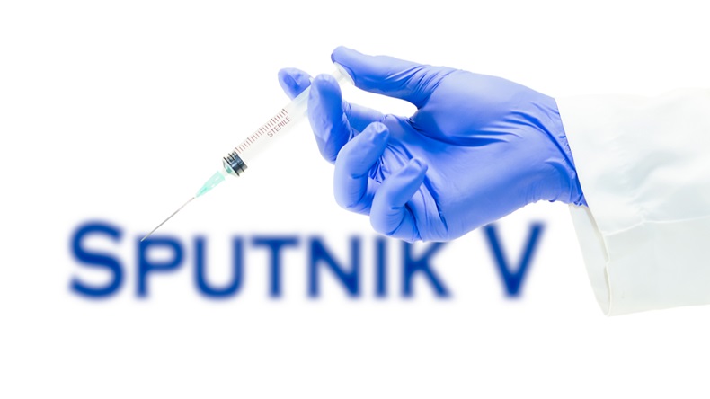 Sputnik v Covid-19 Vaccine - Gloved hand holding syringe containing vaccine