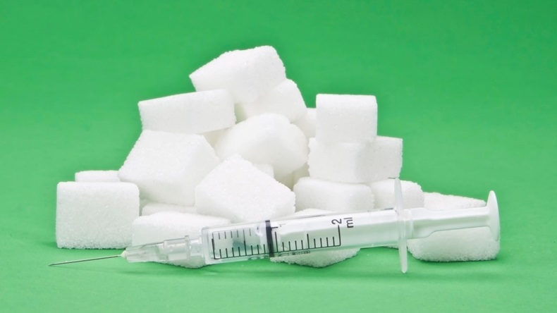sugar cubes with an syringe as a symbol for diabetes
