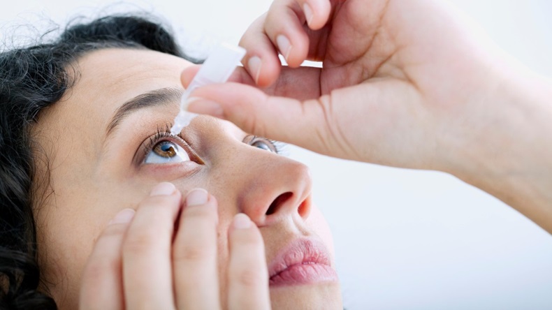 Woman using eye lotion