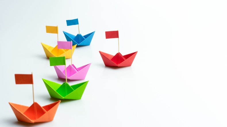 Business competition concept with Colorful paper ships on white background