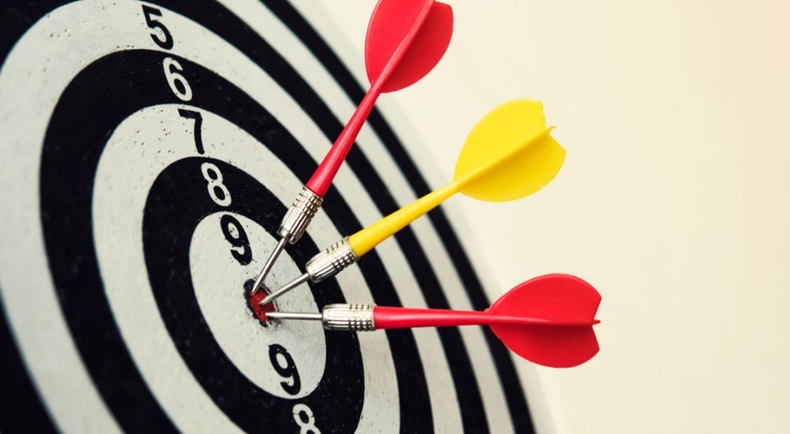 Dartboard with three arrows on bullseye target