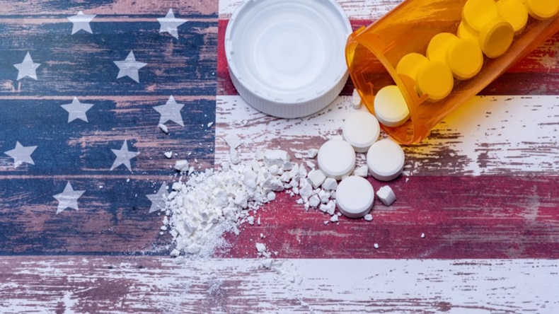 White pills spilled on American flag background