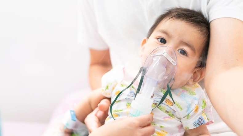 Close up of little baby boy being treated for respiratory problem with vapor nebulizer