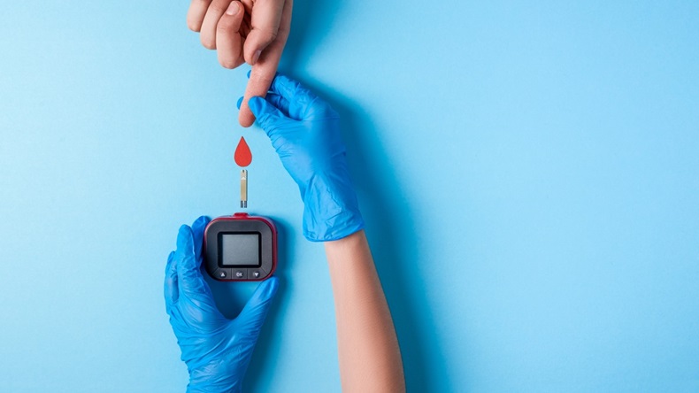 Nurse making a blood test. . Man's hand with red blood drop with Blood glucose test strip and Glucose meter.