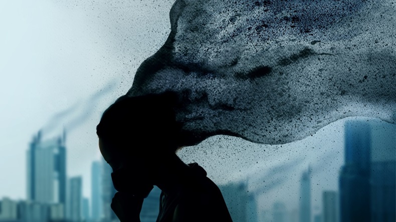 Dark silhouette of person's face on blue city background, depression concept