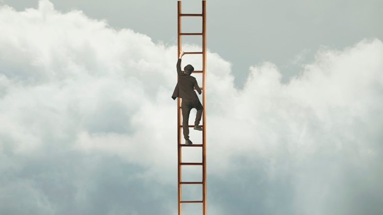 Man in business suit climbing up ladder into the sky, success concept