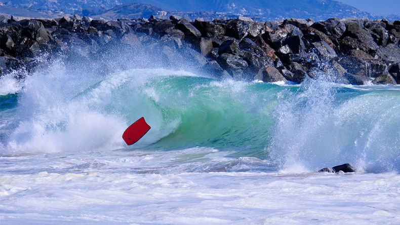 Bright, blue green wave breaks on body boarder and sends red board flying at the Wedge, Newport Beach. - Image 